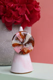 A handcrafted resin ring with brown copper, cream, and pink hues